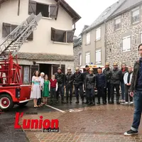 Un groupe de personnes au milieu de véhicules de pompiers.