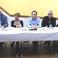 six hommes et une femmes assis derrière une table