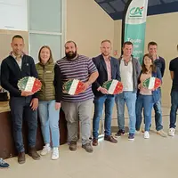 dix personnes debout avec leur trophée en main