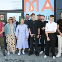 Onze personnes hommes, femmes, posant devant la devanture d'un futur restaurant.