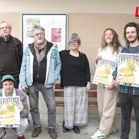 Des gens en train de tenir une affiche pour un festival