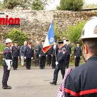 un homme avec un casque de pompier. Un homme portant un drapeau marche vers un autre homme.