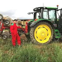 un jeune agriculteur pose devant son tracteur