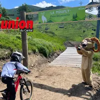un enfant se lance à Vélo encouragé par la mascotte du Lioran
