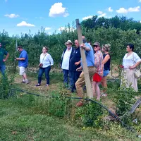 Un groupe de personnes visitent une exploitation agricole renommée pour son activité horticole