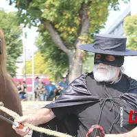 Un éleveur de chevaux lourd conduit sa jument déguisé en Zorro.