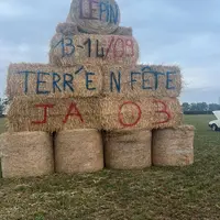 bottes de foin sur lesquelles sont inscrites les dates de la prochaine édition de Terr'en Fête