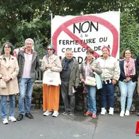 Des enseignants derrière une oancarte