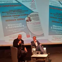 Deux hommes assis en train de faire une conférence