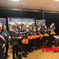 Les élus en écharpes tricolores entourent les jeunes sapeurs-pompiers avec leurs casques à a main.