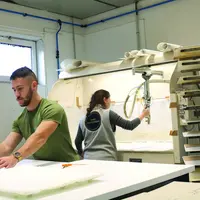 Un homme et une femme en train de travailler le cuir.