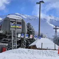 un télésiège avec la montagne enniegée en arrière plan.