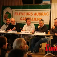 Des personnes assises derreière une table.