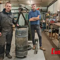 deux hommes dans un atelier autour d'une bobine de moteur électrique