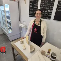 Une femme au centre avec devant elle un echantilon de fromages