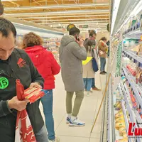 Dans le rayon frais d'une GMS des manifestants vérifient la provenance des produits.