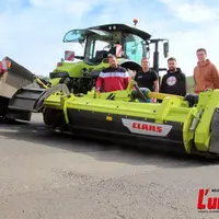 quelques agriculteurs derrière une machine de récolte de l'herbe