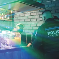 Un policier discute avec un patron de bar.