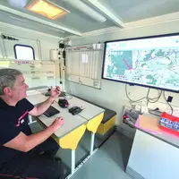 Un sapeur-pompier devant une carte du Cantal.