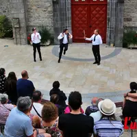 spectacle de rue donné face à une foule sur le parvis d'une église