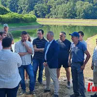 groupe de personnes devant une retenue collinaire d'eau