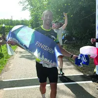 Un finisher franchit la ligne d'arrivée.