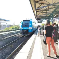 Quai de gare avec un train de la Région Auvergne Rhône-Alpes.