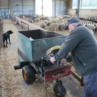 La brouette distributrice est tirée par un moteur de tondeuse à gazon et la roue arrière, mobile et centrale, permet de la diriger facilement.