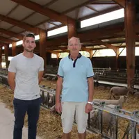 Jeune éleveur et son père en bergerie