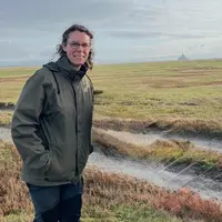 Une éleveuse se tient devant le Mont-Saint-Michel
