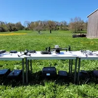 Des drones sont disposés sur une table dans une prairie.