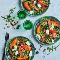 Salade d’agneau aux pêches rôties, chèvre frais, myrtilles et noisettes