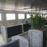 Les containers servant de support aux plantes occupent une surface restreinte dans la case. Chaque panneau béton comprend deux fenêtres pour atteindre