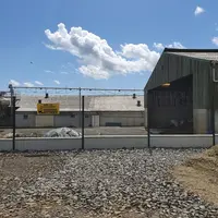 Le coproduit solide de la station de traitement du lisier est chargé dans un camion par dessus la clôture qui sépare la zone d’élevage de la zone prof
