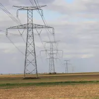 Pylones électriques dans les champs. Gène pour la réalisation des travaux et risque d'accident par électrocution. Electri