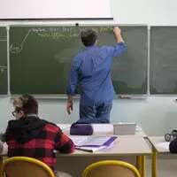 Elèves devant un professeur dans une salle de classe.