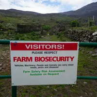 Panneau à l'entrée d'une ferme prévenant des risques d'introduction d'espèces invasives.