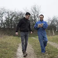 Agriculteur picard et son apprenti en train de marcher sur un chemin rural.