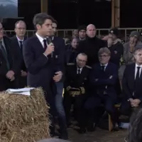Gabriel Attal devant une botte de paille présentant des mesures aux agriculteurs