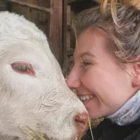 Océane Balland, jeune agricultrice, avec un veau charolais