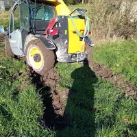 Tracteur embourbé dans un champs  lors d'une opération de taille de haie