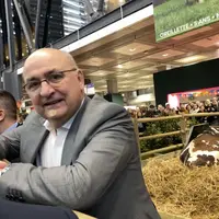 Jean-Luc Poulain, président du salon de l'Agriculture, attendant à côté de la vache Oreillette