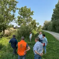 Agriculteur curant un fossé devant la presse