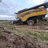 Moissonneuse équipée de chenilles dans la boue