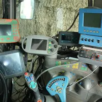 Matériel agricole dont un GPS dans une cabine de tracteur. Les mahcines sont éteintes, les écrans noirs.