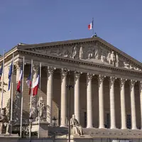 Colonnade de l'Assemblée Nationale. On y voit des drapeaux français.