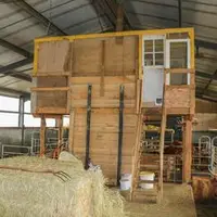 Local d’infirmerie en bois, suspendu en bout du couloir d’alimentation, dans le bâtiment d'élevage.