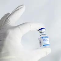 Main gantée tenant un flacon de vaccin à ARN messager de Moderna contre le Sars-Cov-2.