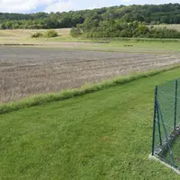 Bande enherbée en zone de non traitement, à proximité d'habitations le long d'un champ de blé.