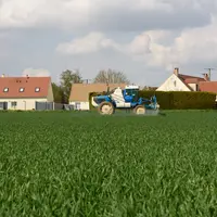 Pulvérisateur devant des maisons.